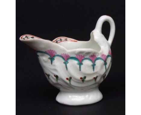 A Lowestoft cream boat circa 1790 shell moulded on a low pedestal foot decorated in neo-classical style with looped arches an