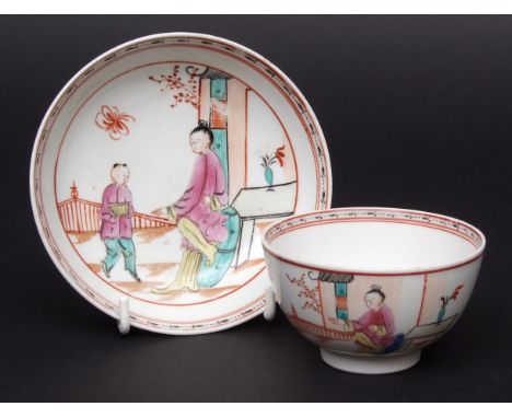 Lowestoft tea bowl & saucer circa 1775 decorated with a chinoiserie design of figures by a fence with an insect hovering abov