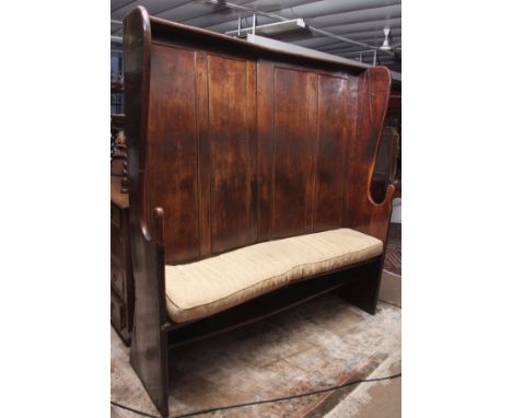 18th century elm wood settle with curved four-panel back, lug side supports, curved hard seat, base shelf, complete with swab