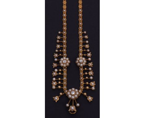 Edwardian yellow metal necklet formed as conjoined disc shaped panels, the front featuring three rosettes of seed pearls with