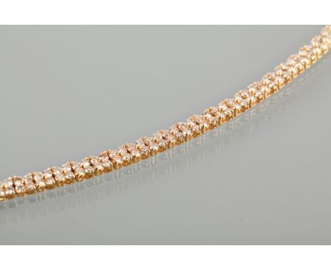 DIAMOND BRACELET
set with clusters of four brilliant cut diamonds totalling approximately 7.00 carats, in eighteen carat yell