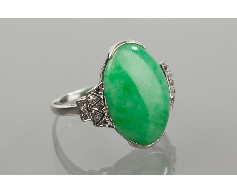 EIGHTEEN CARAT WHITE GOLD NATURAL JADEITE AND DIAMOND DRESS RING 
the large oval cabochon jade measuring approximately 17.6mm