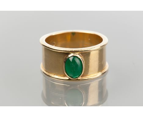 EMERALD RING
set with a central oval cabochon emerald, on a wide band, in eighteen carat gold, 9.0g, size m