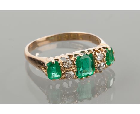 EIGHTEEN CARAT GOLD EMERALD AND DIAMOND RING 
set with three emerald cut emeralds interspaced by pairs of brilliant cut diamo