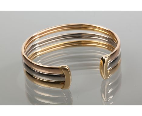 EIGHTEEN CARAT MUST DE CARTIER PARIS TRI-COLOUR TRINITY BANGLE 
comprising yellow, white and rose gold in fitted case