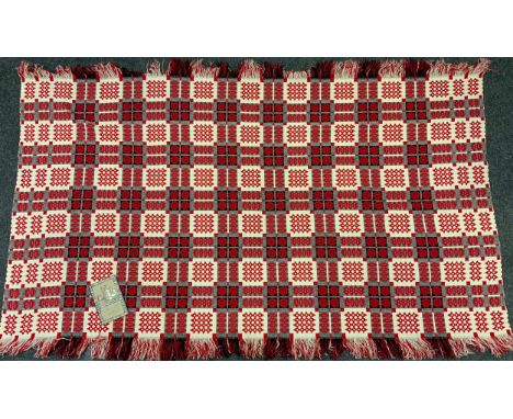 A 20th century Welsh woolen blanket, decorated with a repeating pattern of multi-tone geometric motifs inc black, cream and m