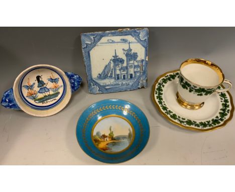 A 19th century Sevres porcelain dished bowl, central panel painted with a Riverside Cottage scene, turquoise and gilt banded 
