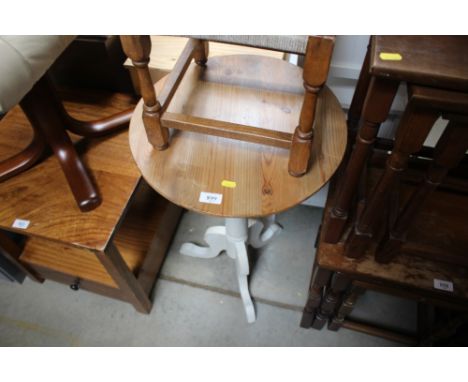 A circular topped pine table raised on tripod base 