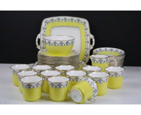 Royal Stafford yellow ground floral china tea set, marked 4895, to include 12 cups &amp; saucers, 12 tea plates, 2 sandwich p