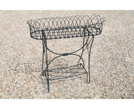Wirework garden plater stand having an oval stand to top raised on shaped supports with lower tier shelf. Measures 81 x 85 x 