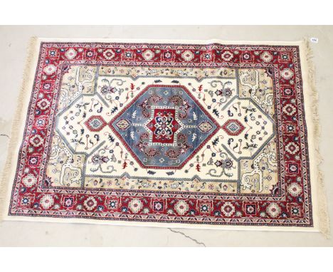 Ivory ground Kashmir carpet with Aztec medallion design, approx 170cm x 115cm 