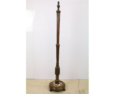 Carved mahogany standard lamp, the fluted column carved with stylised leaf design, on circular base and three feet, 167cm hig