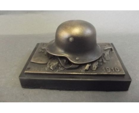 A Replica WWI commemorative paperweight cast as a German helmet and dagger, 5" long 