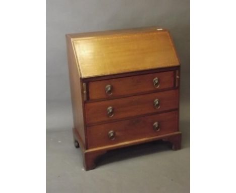 A late C19th mahogany fall front bureau with fitted interior and cross banding, with lion mask handles, on bracket supports, 