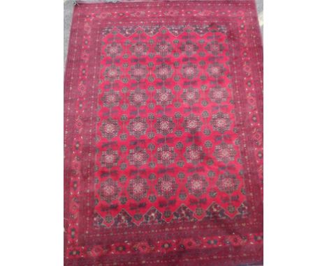 A Persian wool carpet with all over stylised flower design on a red field, 67" x 92" 