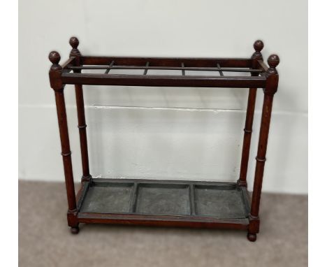 An Edwardian stick stand, with turned finials, dividers and a drip tray, within turned supports; and an Edwardian mahogany di