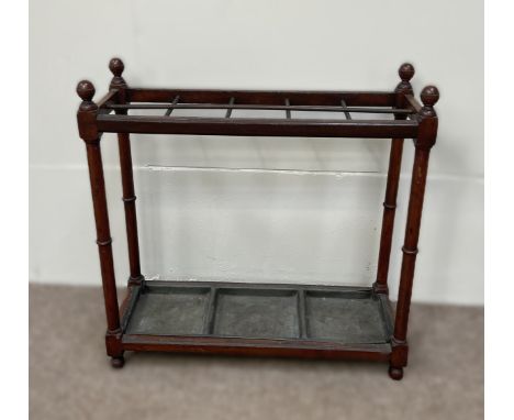 An Edwardian stick stand, with turned finials, dividers and a drip tray, within turned supports; and an Edwardian mahogany di