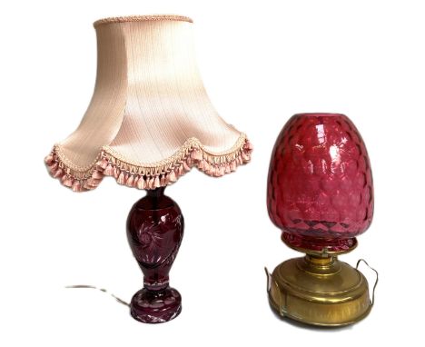 A large late Victorian cranberry glass oil lamp, with a massive &lsquo;honeycomb&rsquo; ovoid cranberry shade and brass reser