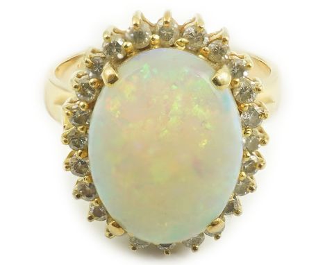 An 18k gold, white opal and diamond set oval cluster ring, size O, gross weight 6.3 grams.  Numerous tiny scratches to the su