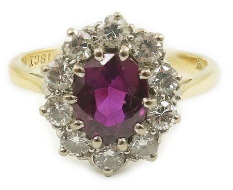 An 18ct gold and platinum, ruby and diamond set oval cluster ring, size N, gross weight 3.6 grams.  Some wear to the facet ed