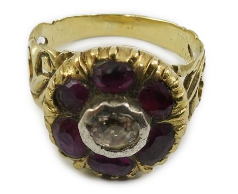 A Georgian gold, ruby and diamond circular cluster ring, set with a central old round cut diamond, bordered by six old cut ru