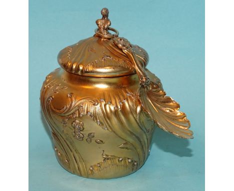 A French silver-gilt tea caddy of baluster form, with embossed scroll and floral decoration, 10.5cm, with spoon of leaf form,