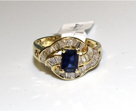 A sapphire and diamond cluster ring claw-set a step-cut sapphire amid three wavy lines of channel-set keystone-cut diamonds, 