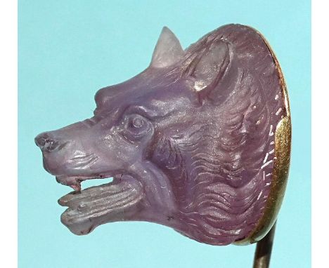 A Queen Victoria interest gold stick pin surmounted by a carved amethyst wolf's head, the mount engraved From the Queen, Bade