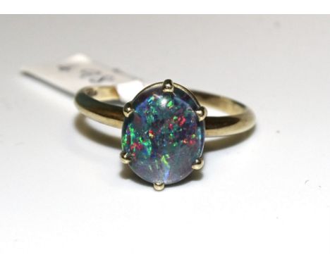 A 9ct gold ring claw-set an opal triplet, size R½, 2.4g. 