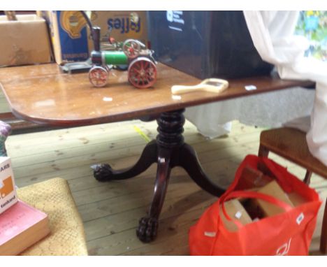 A 1.42m 19th Century mahogany tilt-top table with rounded oblong top, set on turned pillar and quadruple splayed legs with li