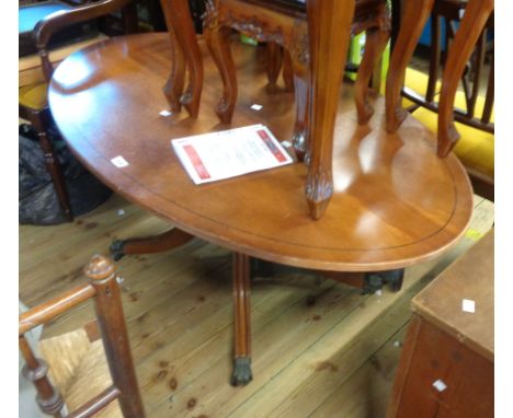 A 1.2m reproduction mahogany and ebony strung oval topped coffee table, set on turned pillar and quadruple splayed legs with 