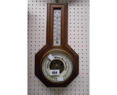 A vintage oak cased wall barometer/thermometer with beaded border and visible aneroid works