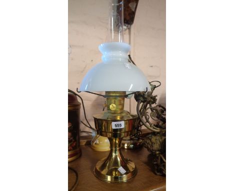 A vintage Aladdin brass oil lamp with original chimney and opaque glass shade