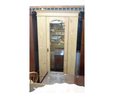 A 95cm late Victorian stripped pine wardrobe with hanging space enclosed by a mirror panel door with drawer under, set on bra