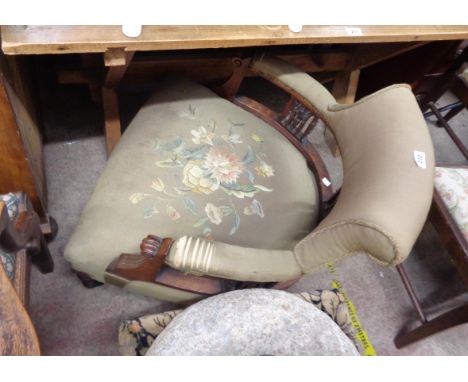 An Edwardian mahogany framed tub elbow chair with green tapestry upholstery and pierced sides, set on turned front legs with 