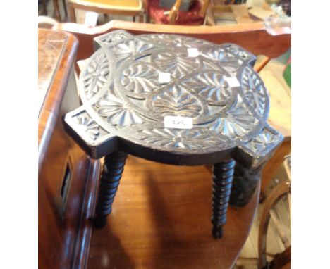 A stained wood stool with carved repeat pattern to top, set on four bobbin turned legs