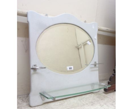 A vintage bathroom wall mirror with cup holder, toothbrush stand and glass shelf under, set on a white painted backboard with