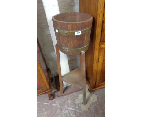 An oak coopered barrel form jardiniere stand, set on tripod base with undertier