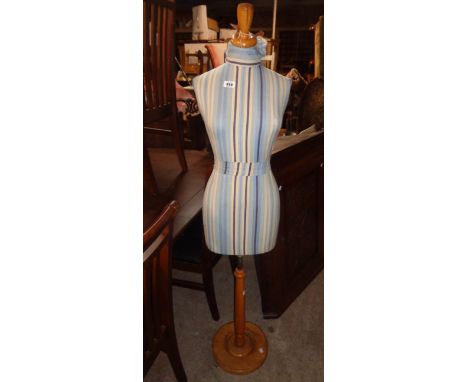 A vintage dressmaker's mannequin with wooden stand and fabric covered body