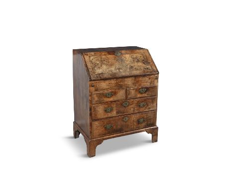 A GEORGE II CROSS AND CHEVRON BANDED WALNUT BUREAU, C.1730  the slopefront top opening to reveal a fitted interior of drawers