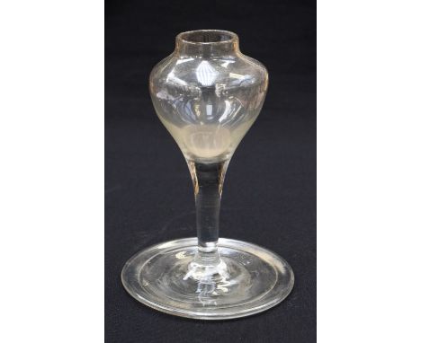 An 18th century glass oil lamp, pedestal form with single reservoir and folded drip tray foot, 16cm high