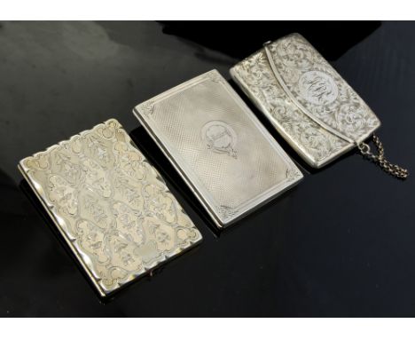 A Victorian silver shaped rectangular card case, chased and engraved with floral motifs, opening to reveal pink silk lined fi