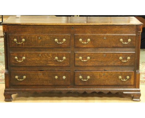 A George III oak and mahogany cross-banded Lancashire dresser base, circa 1780, the hinged lid enclosing storage area, the fr