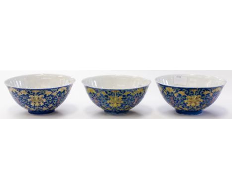 A set of three Chinese blue enamel ground bowls, Guangxi mark, early 20th century, painted with yellow bats between yellow lo
