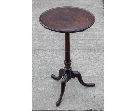 A George III mahogany tripod table, the dished circular top raised on a turned column, standing on cabriole legs, 69cm high