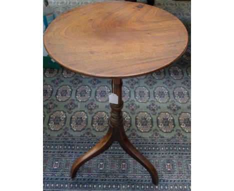 A George III circular top tripod table, the plank top raised on a turned column, standing on downswept legs