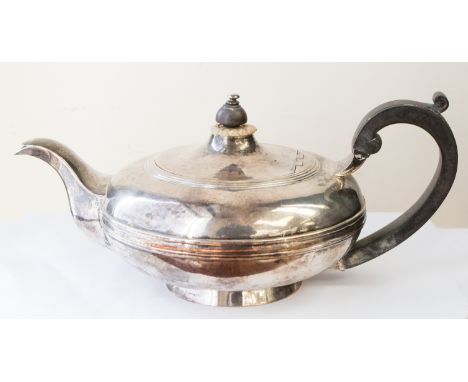 A William IV silver teapot, circular bombe shaped with central rib on raised foot, the body engraved with a flag shaped vigne