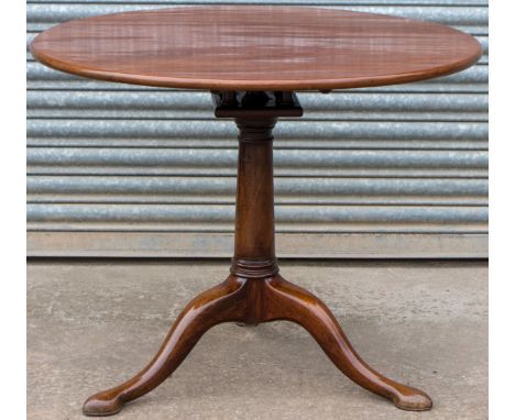 A George III mahogany tilt top tripod table, the circular top raised on a birdcage mechanism and turned column, standing on t