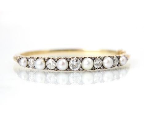 An early 20th century diamond and pearl set bangle, the five old cut diamonds interspersed with rose cut diamonds and culture