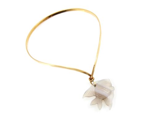 A yellow metal bangle, the wishbone shaped bangle suspending a banded agate carving of a fish, bangle stamped to interior ‘75